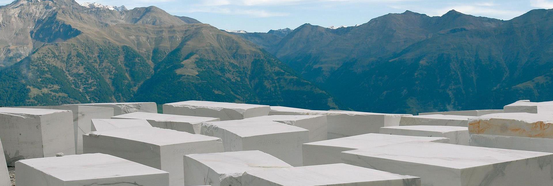 White marble blocks on a mountain plateau with a view of the Dolomites